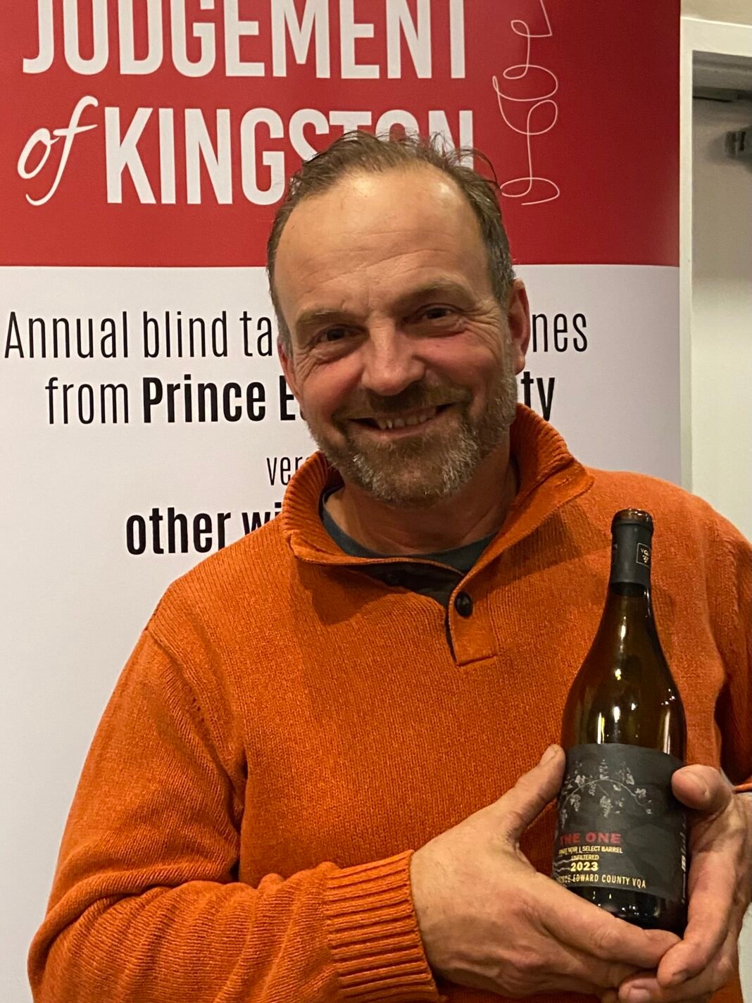 Tim Kuepfer holding pinot noir from Brokenstone winery